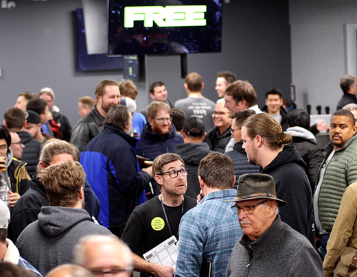A large group of men talking and hanging out in a church lobby